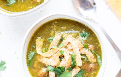 two bowls of chili verde with jackfruit with spoons and a napkin